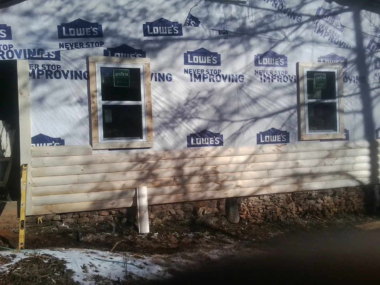 House wrap and new log siding going up on an exterior wall in Belvedere Tiburon