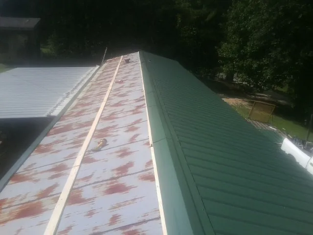 Old rusted panels beside newly installed green metal roofing — Wind Damage Roof Repair by Roofing Brothers in Belvedere Tiburon