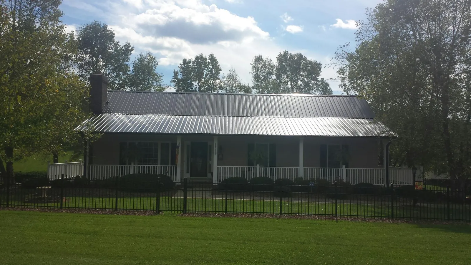 Gray metal roof on a brick ranch with a full width front porch — Gutter Guard Installation work by our crew in Belvedere Tiburon